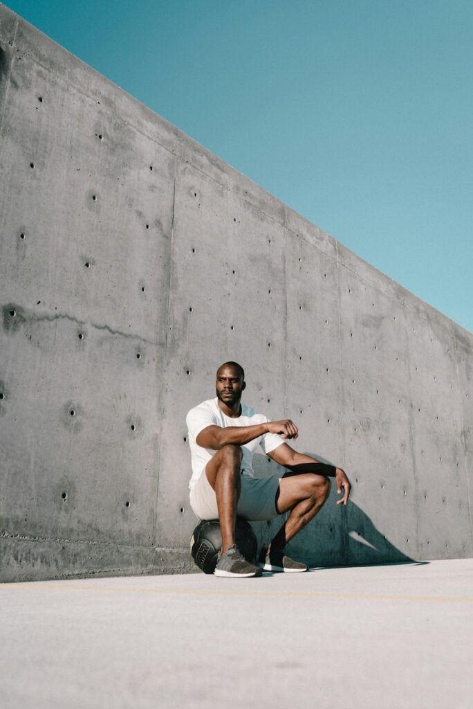 Ultimate Guide to Interior Gym Design for Professionals 4 Urban concrete wall with man crouching.